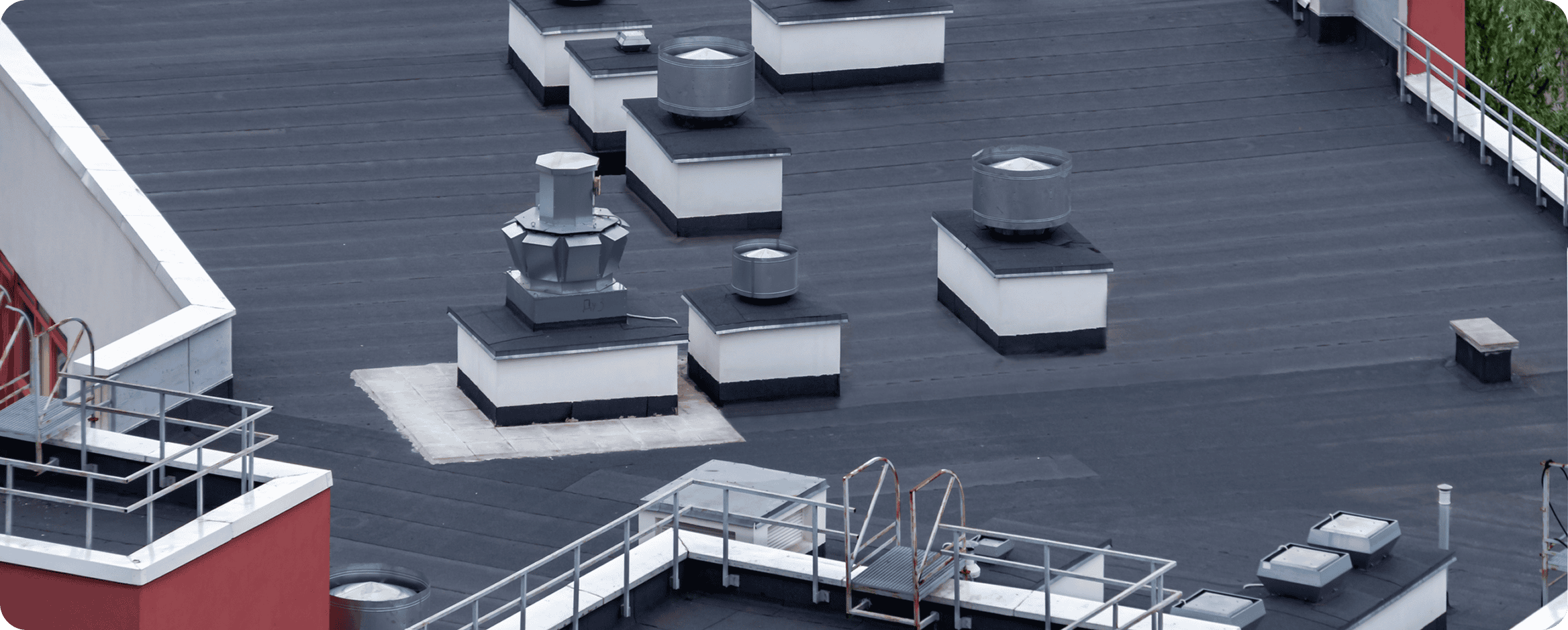 Rooftop with ventilation systems and railings.