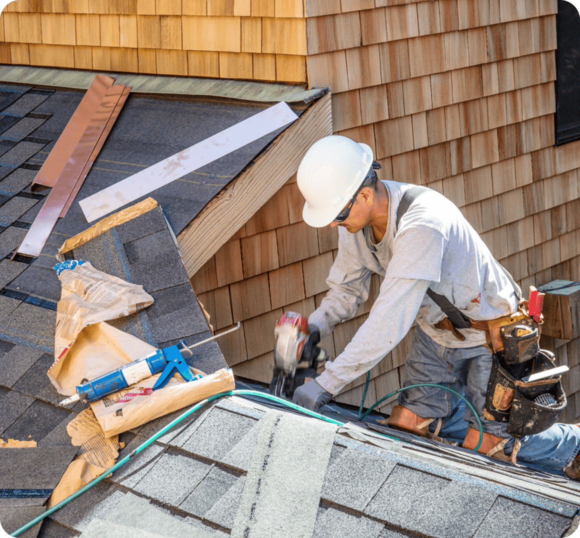 Roofer working on house shingle installation.
