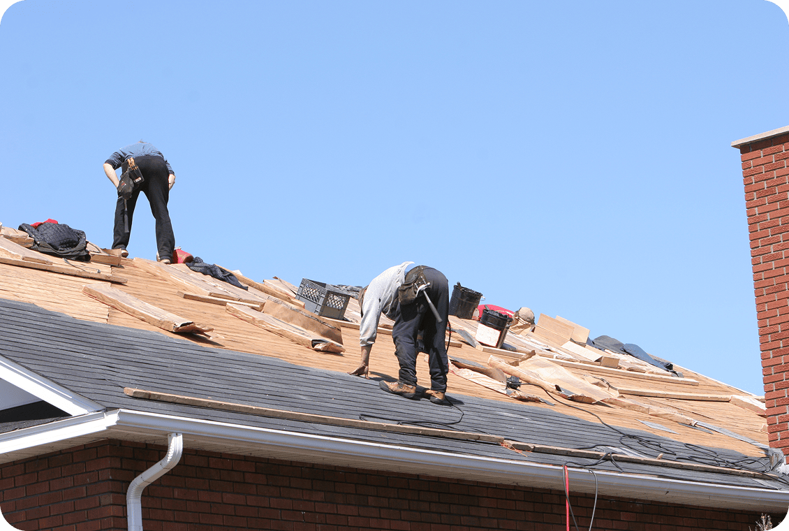 Workers installing shingles on a roof.